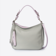 Load image into Gallery viewer, A light sage green hobo shoulder bag with pale pink tassel details and straps, shown against a plain white background.
